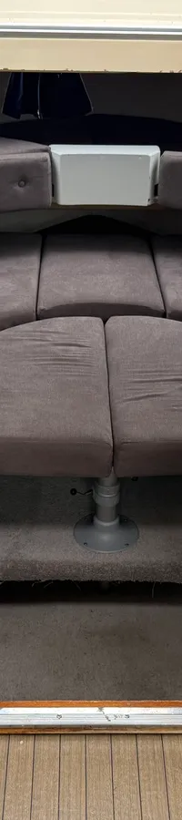 De foto toont het interieur van een boot met een kajuit, een stuurconsole met bedieningspanelen en een blauwe stoel.