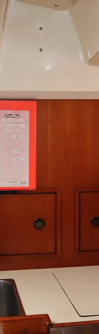 Een bootinterieur met een aanrecht, twee spoelbakken, een kraan, een papieren handdoekrol en een branddeken.