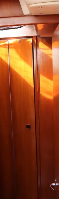 Een interieur van een boot met houten wanden, een open deur, drie ronde meters en een lamp met ventilator. — Contest 38S