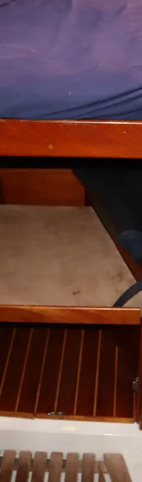 Een houten interieur van een boot met een bed, een wasbak en een houten vloer. — Contest 38S