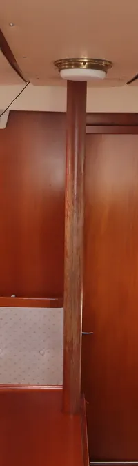 De foto toont het interieur van een boot met houten wanden, beige kussens en een tafel in het midden. — Contest 38S