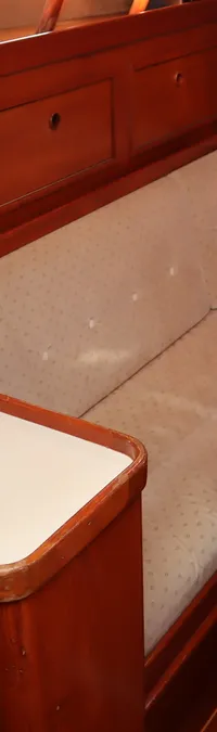 Een interieur van een boot met een L-vormige bank, een tafel en een fornuis met oven. — Contest 38S