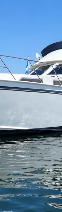 Een witte motorboot met een donkerblauwe kap ligt aangemeerd aan een houten steiger in een jachthaven. — Condor 105 Fly