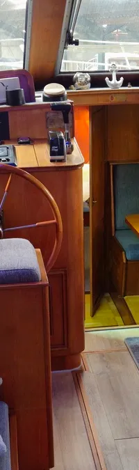 Het interieur van een boot met een stuurwiel, banken, een tafel en een kleine televisie. — Condor 105 Fly