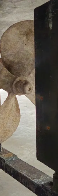 Een detailfoto van de onderkant van een boot met een driebladige schroef en roer. — Condor 105 Fly