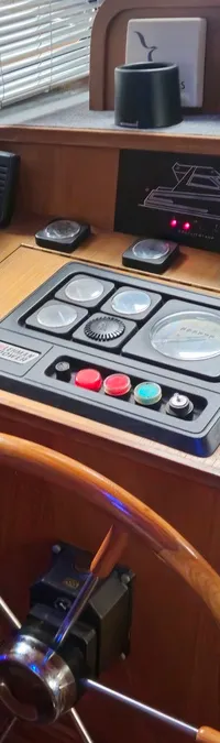 Een houten dashboard van een boot met een stuurwiel, diverse meters, schakelaars en een bedieningshendel. — Condor 105 Fly