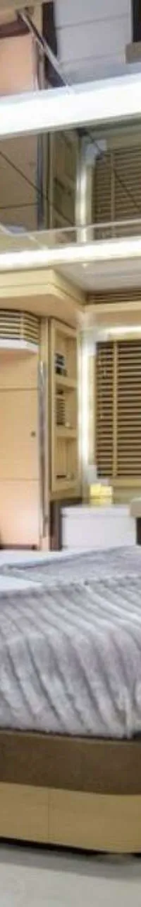 Een luxe slaapkamer met een groot bed, een bureau, een televisie en een spiegelplafond.