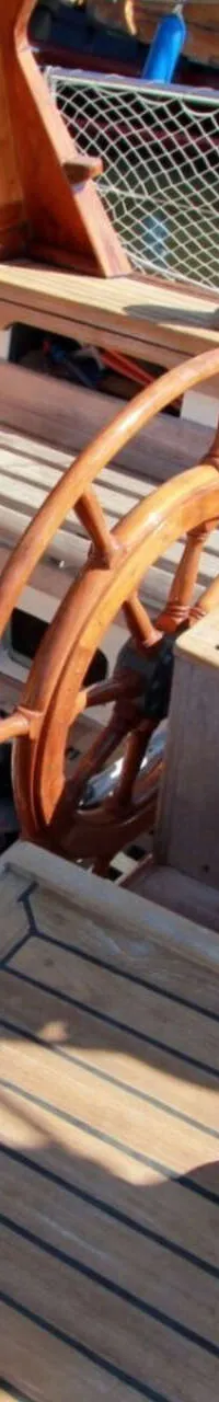 Een houten stuurwiel en deels geopende kajuitdeuren zijn zichtbaar op het dek van een boot. — Volkerak 46