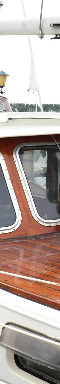 Een witte boot met houten dek en kajuit, met de naam "CECILIA" op de zijkant, ligt aangemeerd. — Bloemsma Kotter 10.50