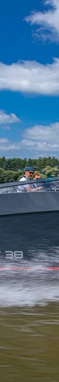 Een donkergrijze motorboot met rode strepen en de tekst "SALUT 38" vaart over water, met twee Mercury buitenboordmotoren.