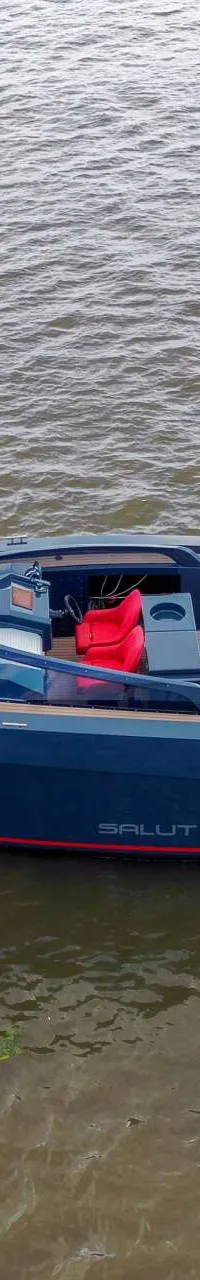 Een donkerblauwe boot met rode accenten en twee buitenboordmotoren ligt op het water. — Salut 38