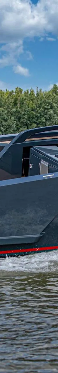 Een donkergrijze motorboot met rode accenten en twee buitenboordmotoren vaart op het water met twee personen aan boord.