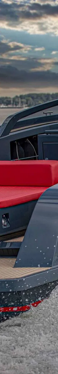 Een grijze motorboot met rode accenten en twee mannen aan boord vaart op water onder een bewolkte zonsondergang. — Salut 38
