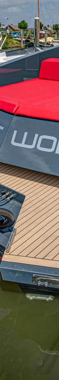 Een grijze boot met rode kussens en de naam "LONE WOLF" op de achtersteven, met twee zwarte Mercury buitenboordmotoren.