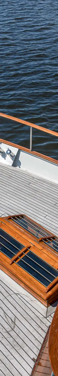 Een bovenaanzicht van het voordek van een boot met houten dek, fenders, luiken en een reling. — Kok Spitsgatkotter 16.50