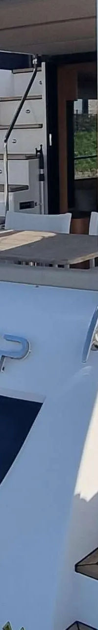 Een witte motorboot met de naam "AMAN DEEP" en "STEENBERGEN" op de spiegel, ligt aangemeerd. — Absolute Navetta 58 Trawler