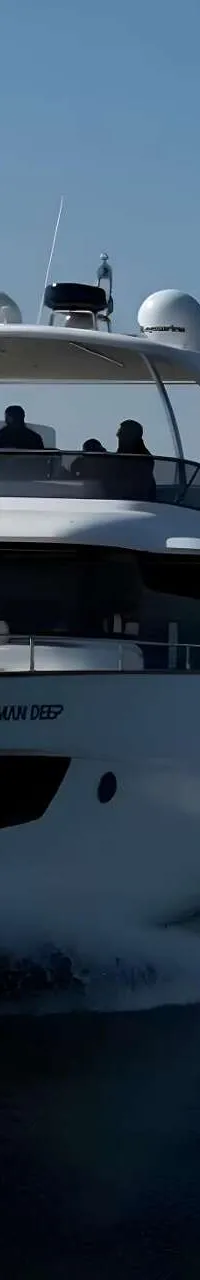 Een witte motorboot met de naam "AMAN DEEP" vaart over rustig water, met een kielzog achter zich.