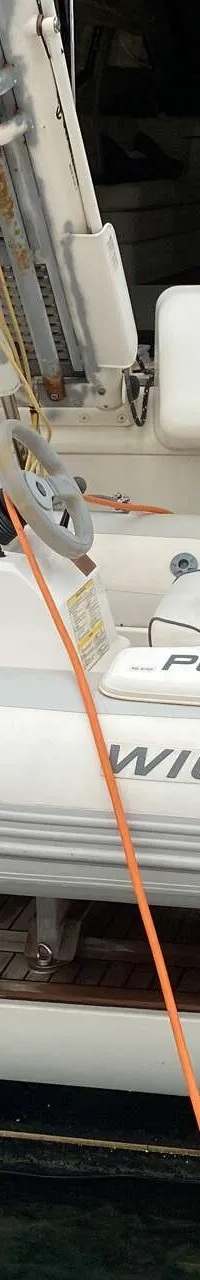 Een witte bijboot met de naam "PENNY" en "WILLIAMS" erop, hangt aan de achterkant van een grotere boot. — Ferretti 510