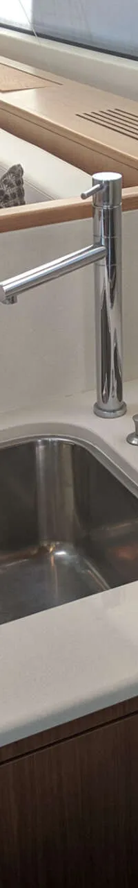 De foto toont een kombuis met een spoelbak, kraan, afdruipbak en een kookplaat met twee pitten.
