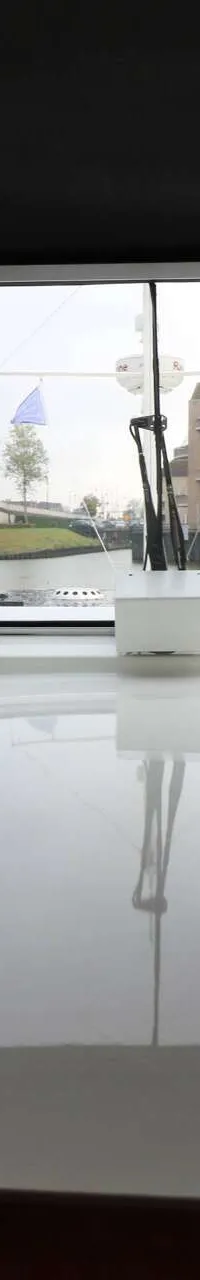 Een interieurfoto van een boot met uitzicht door de voorruit op een brug, water en gebouwen. — Boarncruiser 50 Classic Line