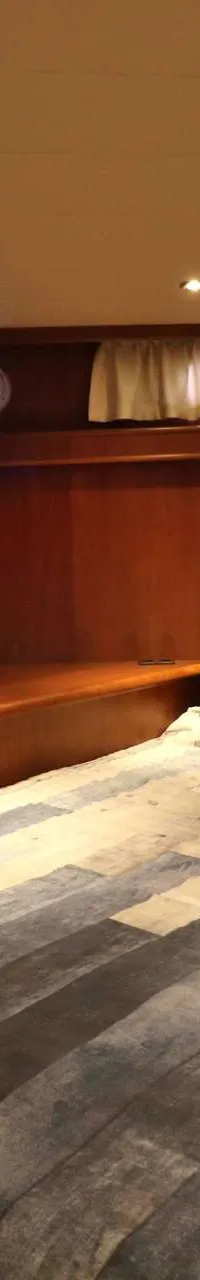 Een kajuit met een tweepersoonsbed, een bankje, houten wanden en een raam met gordijnen. — Boarncruiser 50 Classic Line