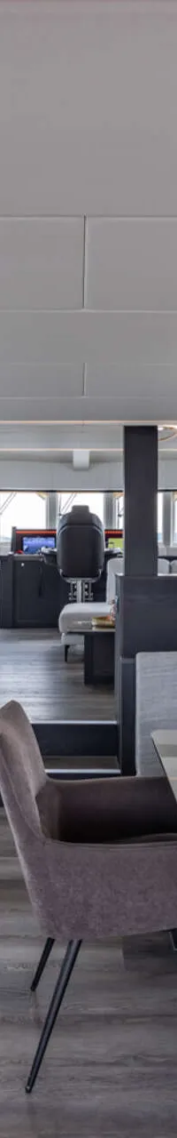 Een moderne kombuis en eethoek aan boord van een jacht, met uitzicht op water en de stuurhut. — Bloemsma Trawler 70