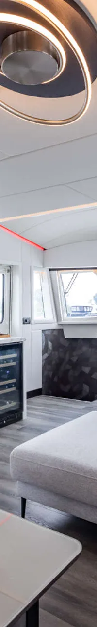 Een interieur van een jacht met een zithoek, stuurstand, bar en een wijnkoelkast. — Bloemsma Trawler 70
