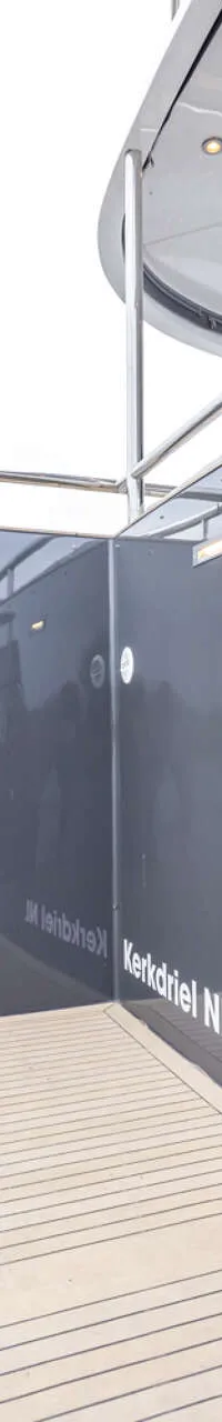 De achterkant van een grijs jacht met de tekst "Dutch Lion" en "Kerkdriel NL" op de spiegel, met een zwemplateau en een…