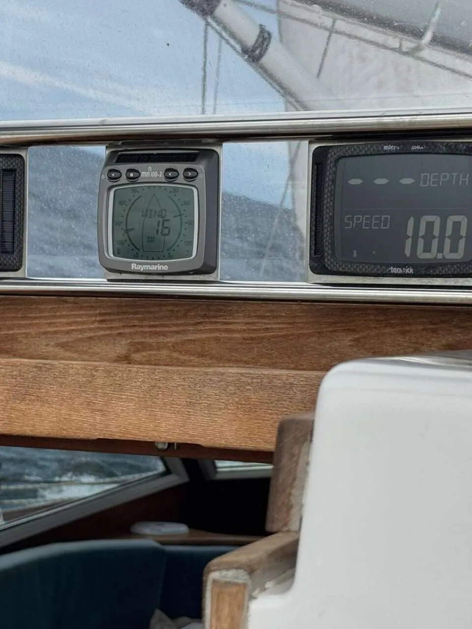 Een donkerblauwe zeilboot met een teakdek en een witte opbouw ligt afgemeerd in een haven. — Nordbaelt 50