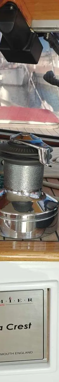 Een interieur van een boot met houten afwerking, een lier, een Raymarine-scherm en een naamplaatje "Sandia Crest".