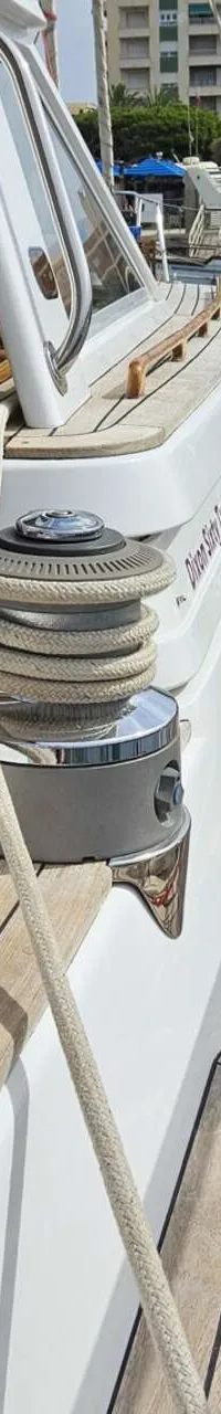 Een dek van een boot met twee lieren, touwen, een stootwil en een houten reling, liggend in een haven. — Premier Dixon  62