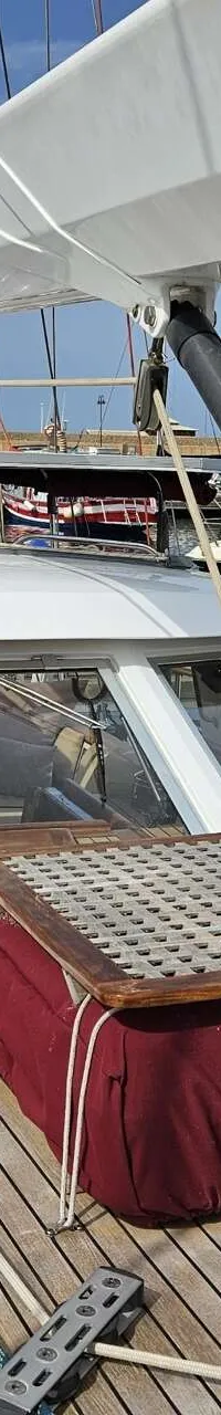 Een bovenaanzicht van het dek van een zeilboot met een kajuit, mast en giek, liggend in een haven. — Premier Dixon  62