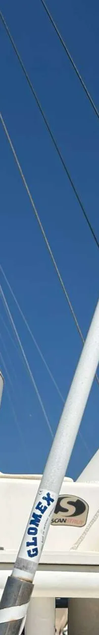 Een witte Raymarine radar en een witte Kymeta satellietkoepel zijn gemonteerd op een mast, met de naam "Grand Cru"…