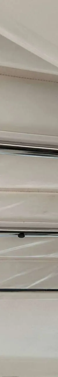Een detailfoto van de binnenkant van een witte bootkap met metalen stangen en een "DE VALK YACHT BROKERS" logo.
