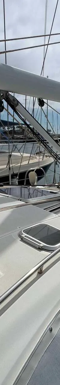 Een zeilboot met de naam "SPARTA" op de giek ligt in een haven met andere boten. — Jeanneau Sun Odyssey 54 DS