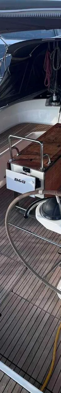 De cockpit van een zeilboot met twee stuurwielen, een houten tafel en een donkere bimini. — Bavaria 55 Cruiser