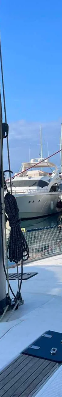 Een zeilboot ligt in een jachthaven met andere boten, gezien vanaf het dek van de zeilboot. — Bavaria 55 Cruiser