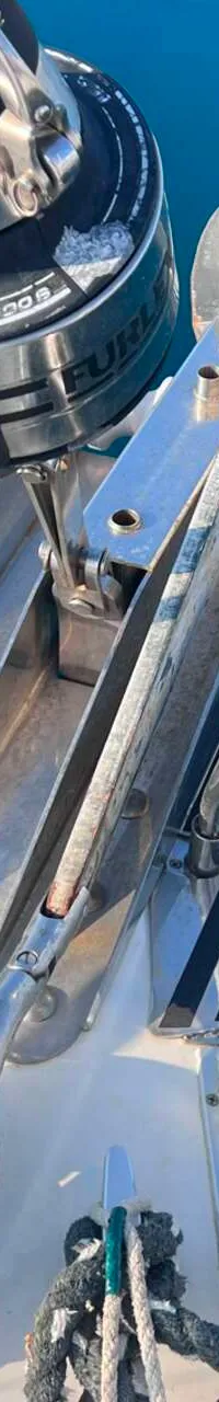 De foto toont de boeg van een boot met een anker, een rolfokinstallatie, een ankerlier en diverse lijnen.