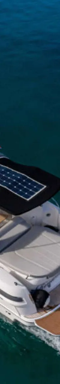 Een witte motorboot met een bruin dek en zwarte bimini met zonnepanelen vaart op blauw water. — Bavaria S29