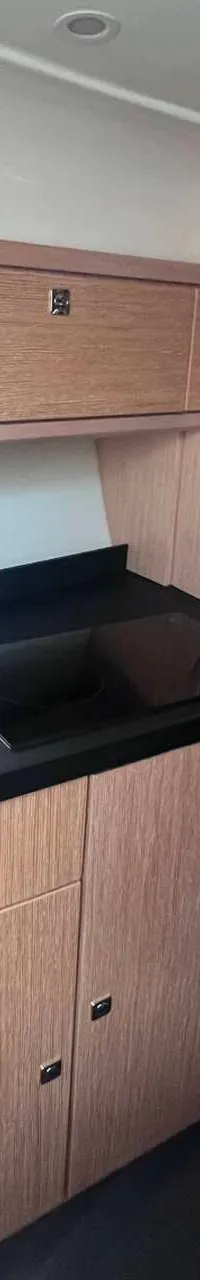 Een kajuit met een keukenblok met spoelbak en kookplaat, en een zithoek met tafel. — Bavaria S29