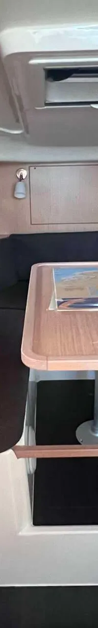 De foto toont het interieur van een boot met een zithoek, een tafel en een keukenblok. — Bavaria S29