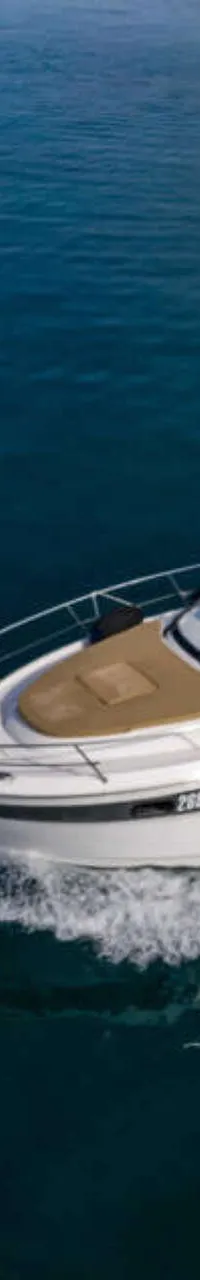 Een witte motorboot met een zwarte bimini en zonnepanelen vaart over donkerblauw water, een kielzog achterlatend.