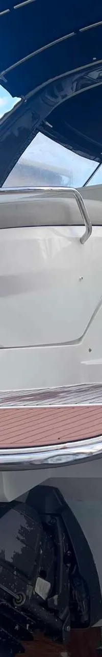 Een witte motorboot met de naam "Rina BAVARIA" op de spiegel, staat op bokken met twee buitenboordmotoren. — Bavaria S29