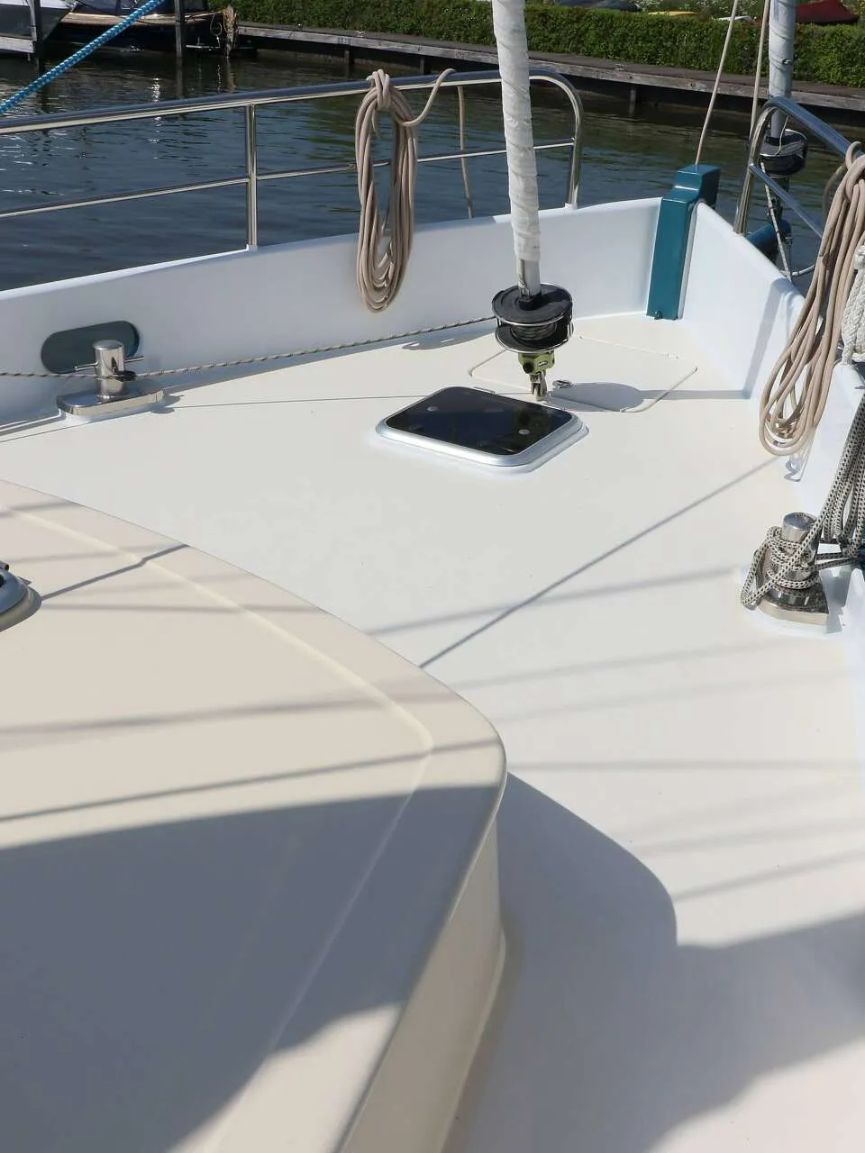 De foto toont het voordek van een boot met een luik, een mastvoet, bolders, relingen en touwen. — Noordkaper 48 -S