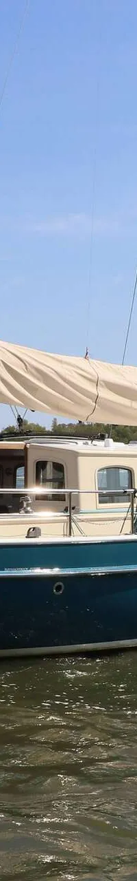 Een zeilboot met een blauwe romp en crèmekleurige opbouw vaart op een zonnige dag over rustig water. — Noordkaper 48 -S
