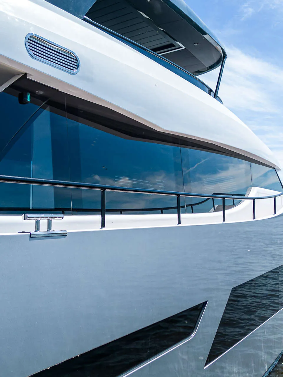 Een witte boot met donkere ramen en een reling vaart op het water onder een blauwe lucht. — Van der Heijden Phantom 80