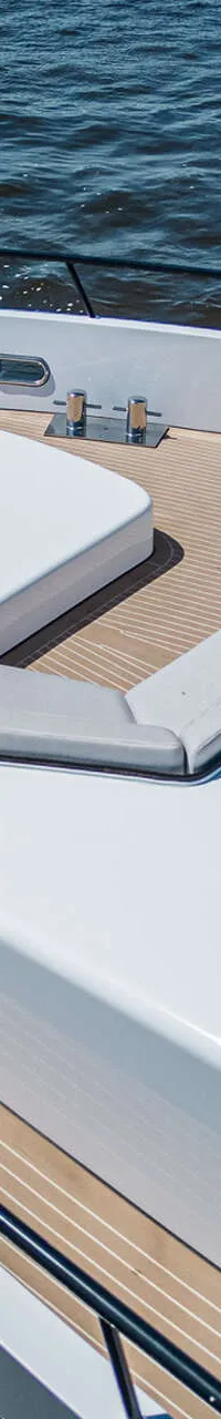 Een bovenaanzicht van de boeg van een witte boot met een teakdek, zitbanken en een tafel. — Van der Heijden Phantom 80