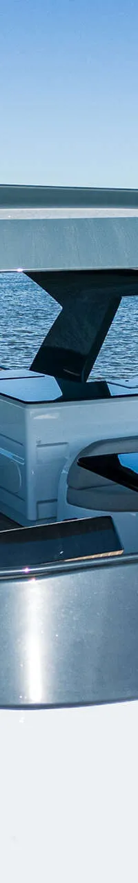 Een witte boot met een grijs dak en een teakdek, met twee tafels en banken, vaart op open water. — Van der Heijden Phantom 80