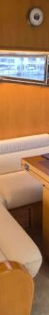 De foto toont een interieur van een boot met een U-vormige bank, een tafel, ramen en een ventilator. — Johnson 56