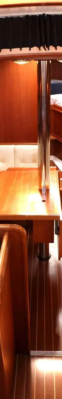 De foto toont het interieur van een boot met een kombuis, salon en doorgang naar een hut. — Victoire 1270